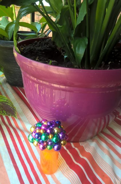 bead camouflaged bottle beside the plant